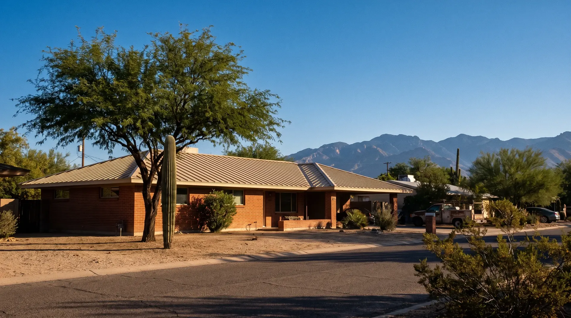 New sandstone tan standing seam metal roof on a Tucson brick ranch home with the Santa Catalina Mountains behind